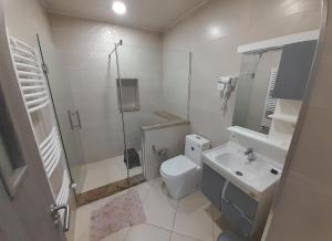 a white bathroom with a toilet and a sink at Appartement l'écho des vagues in Delmonte