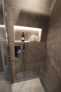 a bathroom with a shower with a bottle of wine on a shelf at Tudor Cottage, Hot Tub, Sleeps 8 in Llandudno +50 photos