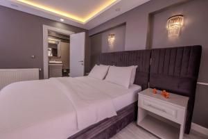 a bedroom with a large white bed with a wooden headboard at Classio Hotel Kadıköy in Istanbul