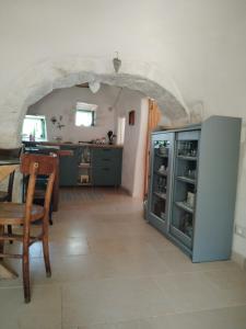 a kitchen and dining room with an archway and a table at Trullo Amedee in Ostuni
