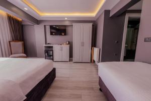 a hotel room with two beds and a kitchen at Classio Hotel Kadıköy in Istanbul