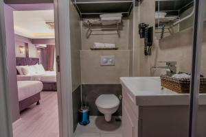 a bathroom with a toilet and a sink and a bed at Classio Hotel Kadıköy in Istanbul +33 photos