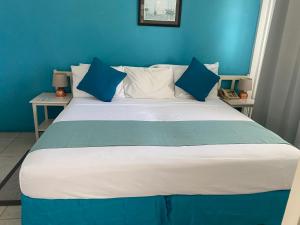 a blue bedroom with a large bed with blue walls at Melrose Beach Apartments Inc in Bridgetown +11 photos