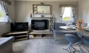 a living room with a flat screen tv and a couch at West Lawn 47 Haggerston Castle Paddock Views in Berwick-Upon-Tweed