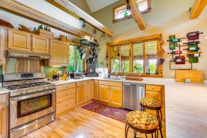 Una cocina con gabinetes de madera y electrodomésticos de acero inoxidable. en Greensboro Home with Porch and Countryside Views!, en Greensboro