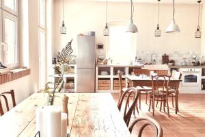 a kitchen with a table and chairs and a refrigerator at dALL in Śmidzięcino +30 photos