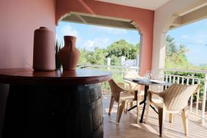 a dining room with a table and chairs on a balcony at Résidence Terre et Passion in Ducos