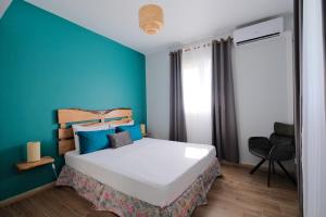 a bedroom with a large bed with a blue wall at Résidence Terre et Passion in Ducos +128 photos