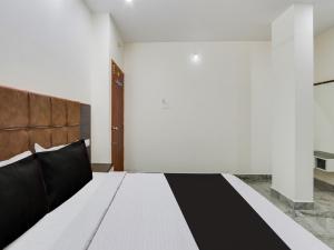 ein Schlafzimmer mit einem Bett mit einer schwarzen und weißen Decke in der Unterkunft Hotel O Arjun Residency in Khammam + 35 Fotos