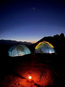 two tents sitting on top of a field at night at Outdoor Adventures Camp Pirchanasi in Muzaffarabad