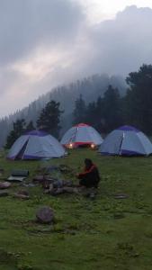 a group of tents in a field in the rain at Outdoor Adventures Camp Pirchanasi in Muzaffarabad