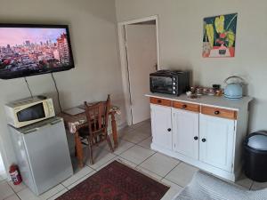 a kitchen with a microwave and a tv on the wall at Valley View in Waterfall