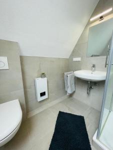 a bathroom with a toilet and a sink at Maisonette Apartment - Ruhig und gemütlich wohnen auf zwei Ebenen in Grohn