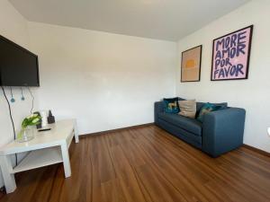 a living room with a blue couch and a table at Maisonette Apartment - Ruhig und gemütlich wohnen auf zwei Ebenen in Grohn