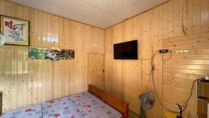 a room with wood paneled walls and a tv at Kien's House - Cam Lap Cam Ranh in Hiệp Mỹ