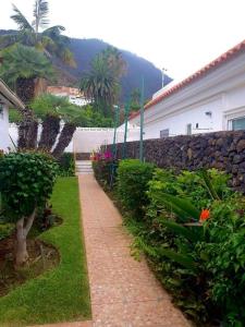 a garden with a brick walkway next to a building at El Refugio del Valle in La Orotava
