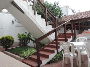 escalera con mesa, sillas, mesa y escaleras en Hotel Aldea Marina, en Villa Gesell