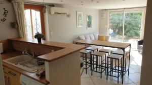 una cucina con bancone e un bar con sgabelli di Orteils au soleil jardin parking a Nîmes