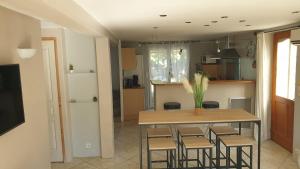 una cucina con tavolo, sedie e frigorifero di Orteils au soleil jardin parking a Nîmes Altre 3 foto