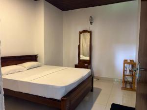 a bedroom with a bed and a mirror at Himo Guest Inn in Dehiwala