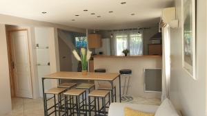 una cucina con tavolo e sgabelli in una stanza di Orteils au soleil jardin parking a Nîmes