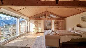 una camera da letto con un letto e una grande finestra di Charming 6 bed chalet in 4 Valleés a Iserables