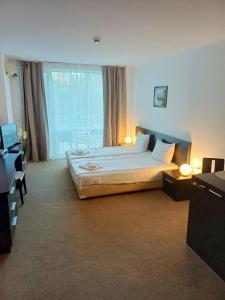 Un dormitorio con una cama y una ventana grande. en Atlantis Resort D111 апартамент, en Burgas 26 fotos más