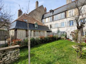 stary dom z ogrodem przed nim w obiekcie La Cour du Château w mieście La Charité-sur-Loire