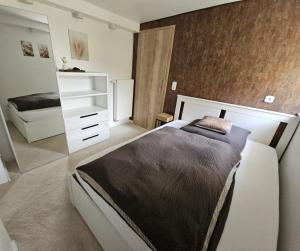 ein Schlafzimmer mit einem weißen Bett und einer weißen Kommode in der Unterkunft Gemütliche Ferienwohnung im Westerwald - "Ferienwohnung Braun" in Weitefeld
