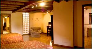 a living room with a bed and a chair in it at Casa do Cura in Beigondo