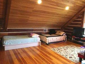 two beds in a room with wooden ceilings at RUSTIC ARMADILLO CABIN with VIEW BY HIDDEN FALL PARK, Fenced yard for Dogs in Smithwick