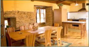 uma sala de jantar com uma mesa de madeira e cadeiras em Casa do Cura em Beigondo