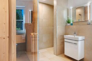 a bathroom with a sink and a shower at Ferienhaus Strandperle in Zingst +21 photos