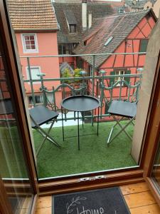 een balkon met een tafel en stoelen bij Édouard & Richard in Colmar