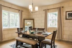 a dining room with a wooden table and chairs at Golden Acre Beach Villa-2 mins walk - Alleynes Bay in Saint James