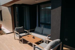 a patio with a couch and two chairs and a table at LuxDS in Tuzla