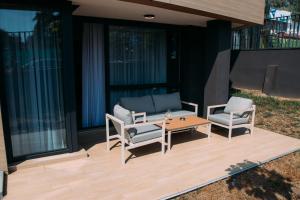 a patio with a couch and two chairs and a table at LuxDS in Tuzla