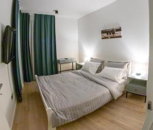 a bedroom with a bed and a green curtain at LuxDS in Tuzla
