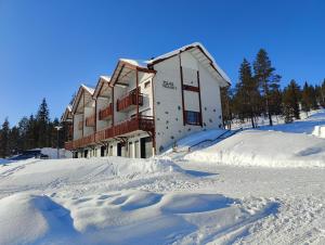 a building in the snow with a lot of snow at Laskijanlinna in Ylläs