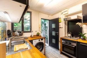 una cucina con lavatrice e asciugatrice in una casa di Oasis urbain a Saint-Maur-des-Fossés
