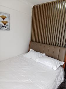 a bed with white sheets and pillows in a room at Smarthome Serviced Apartments B1005 in Nairobi