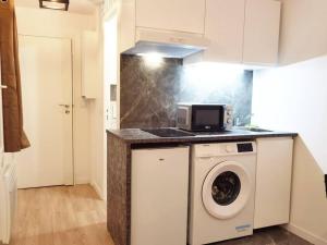 a kitchen with a washing machine and a microwave at New renoveted studio in calm area near nation in Paris