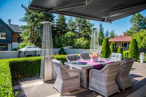 een terras met een tafel, stoelen en een parasol bij Villa 1331 in Zheleznitsa