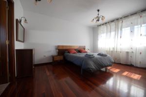 a bedroom with a bed and a wooden floor at Chalet grande en Soto de la Marina in Liencres