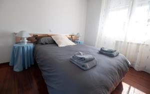 a bedroom with a large bed with towels on it at Chalet grande en Soto de la Marina in Liencres