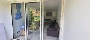 a living room with a couch and a sliding glass door at LABROUSSE appartement - possibilité location véhicule in Le Gosier