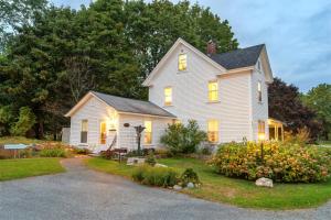 a white house with lights on in the yard at Bar Harbor Cottages & Suites in Bar Harbor