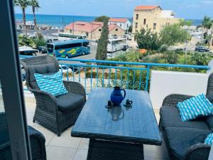 a table and chairs on a balcony with a view of the ocean at Blue Lagoon Latsi Centre in Lachi