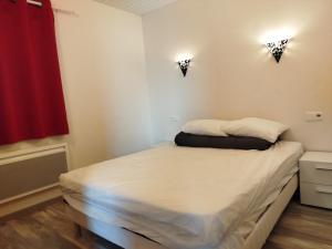 a bed in a room with two lights on the wall at Appart'Hôtel Les ACACIAS courte et longue durée in Bischoffsheim +2 photos