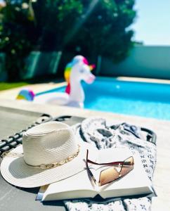 a hat and sunglasses sitting on a table next to a swimming pool at Luxury Villa LAPIS LAZULI in Meneou